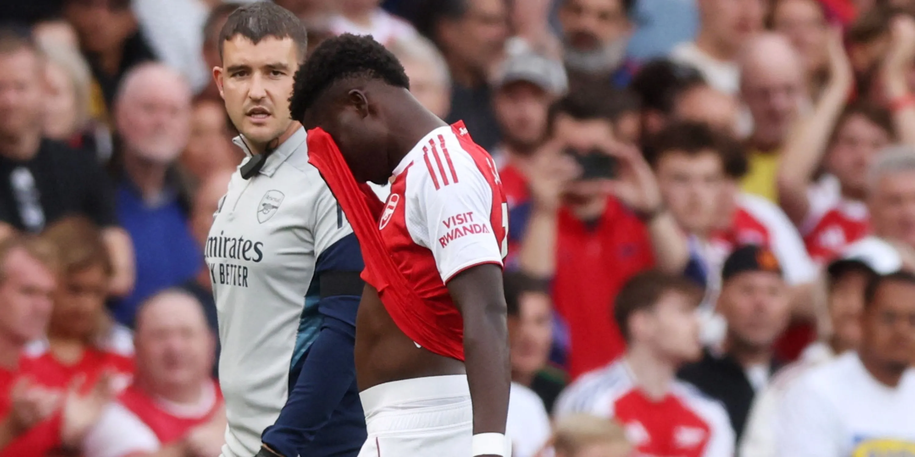 Bukayo Saka ngồi trên sân với vẻ mặt thất vọng sau khi dính chấn thương gân kheo trong trận đấu của Arsenal